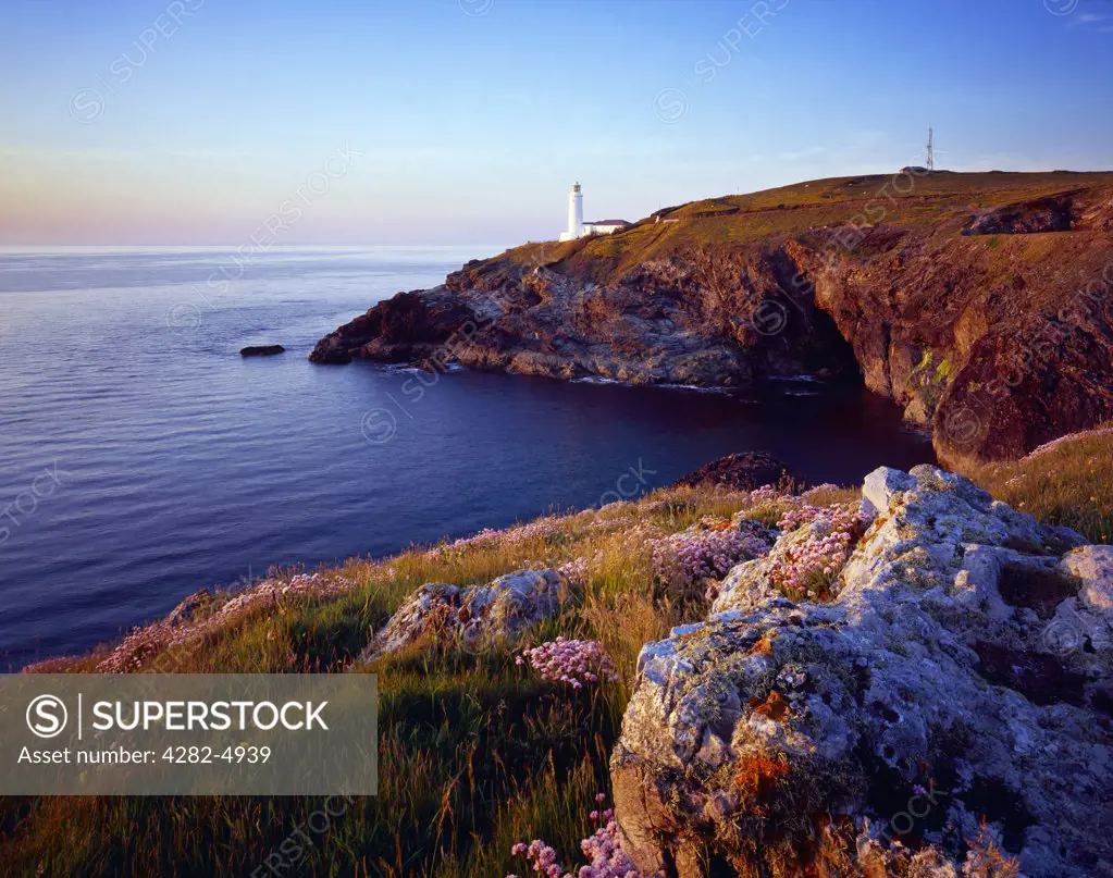 England, Cornwall, Trevose Head. Stinking Cove and the lighthouse at Trevose Head at sunset viewed from Dinas Head on the North Cornwall coast near Padstow.