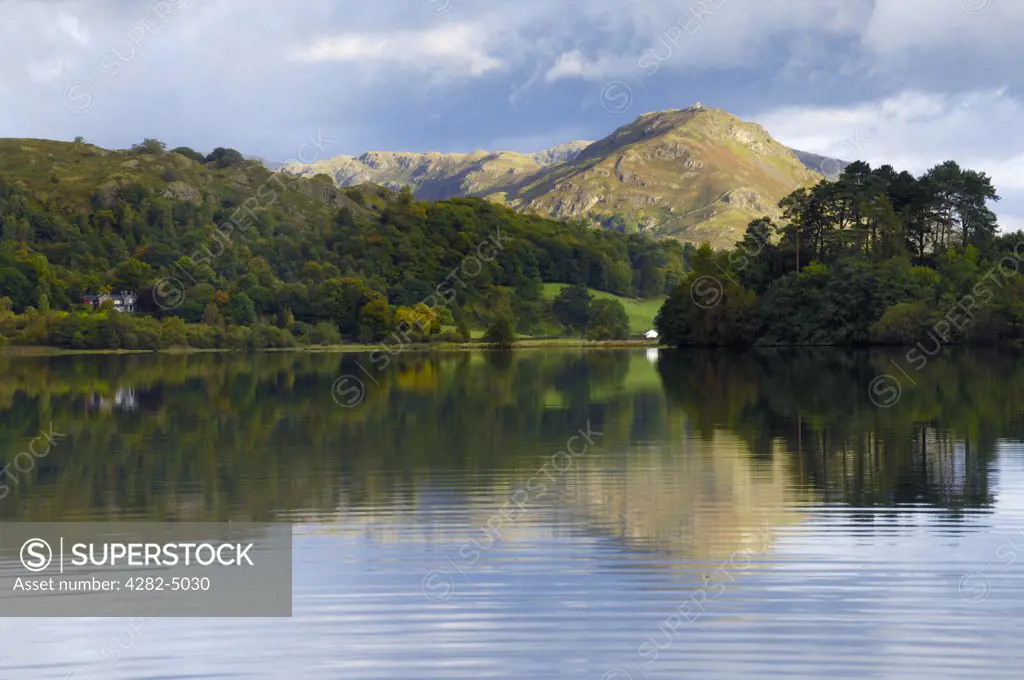 England, Cumbria, Grasmere. Early morning sunlight on Helm Crag in autumn from Grasmere in The Lake District National Park.
