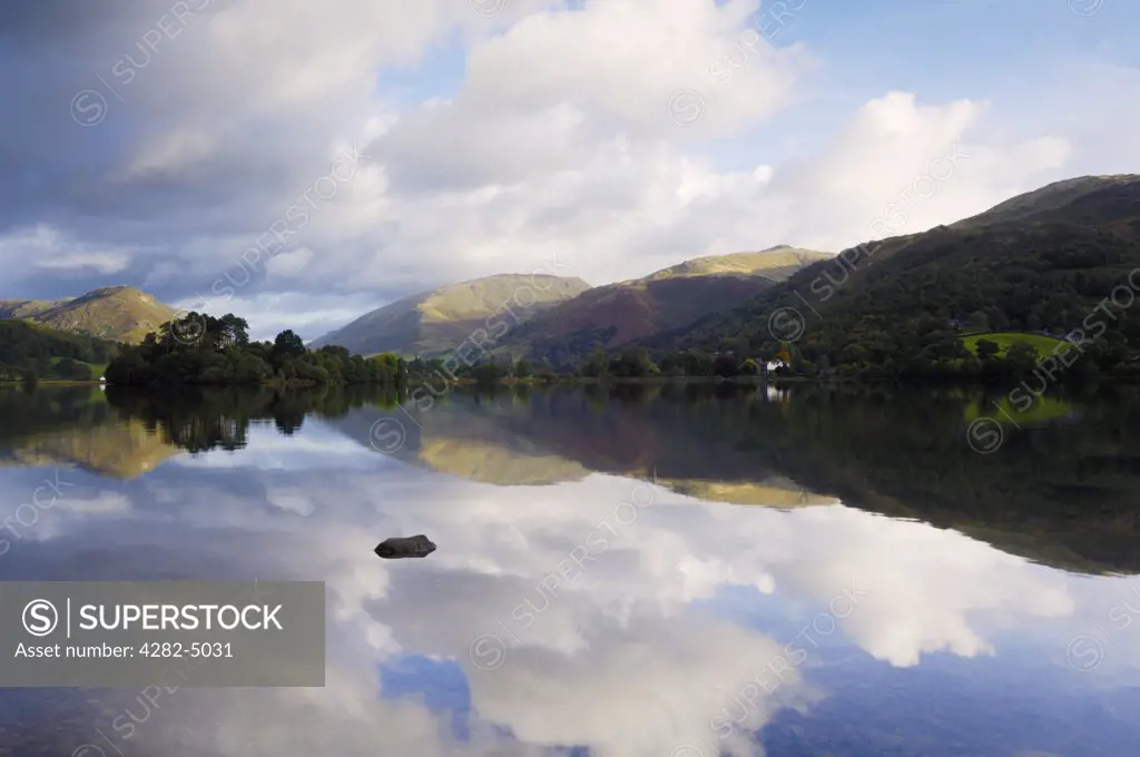 England, Cumbria, Grasmere. Early morning autumn sun illuminates the mountains at Grasmere in The Lake District National Park.