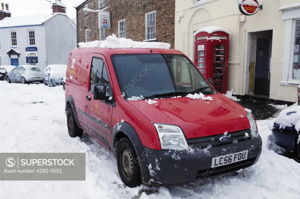 England, Somerset, Wrington. A Royal Mail post van outside a village Post Office in the snow.