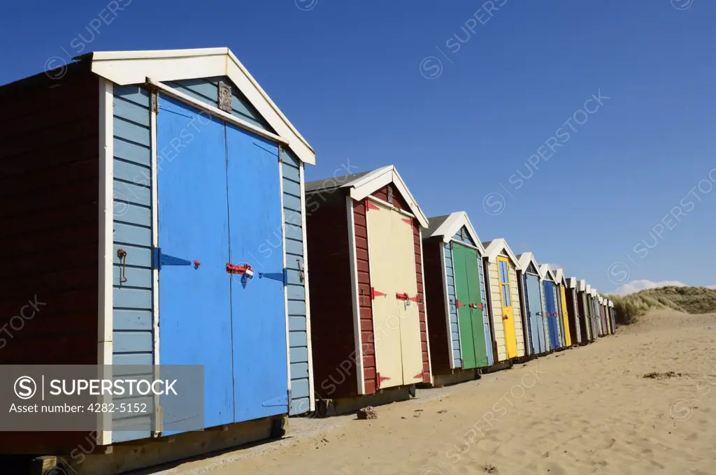 England, Devon, Braunton. Beach huts on the beach at Saunton Sands near Braunton on the North Devon coast.