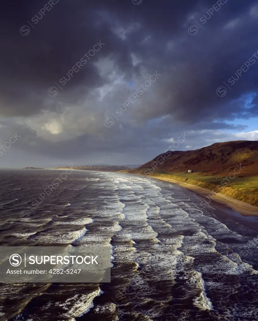Wales, Swansea, Rhossili. Waves rolling onto the beach at Rhossili Bay on the Gower peninsula.