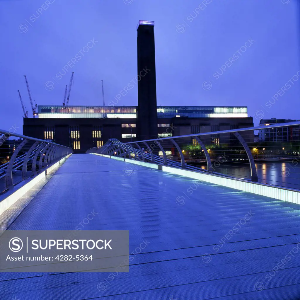 England, London, Southwark. Tate Modern and Millennium Bridge at dusk. The museum was designed by Sir Giles Gilbert Scott, who also designed Battersea Power Station.