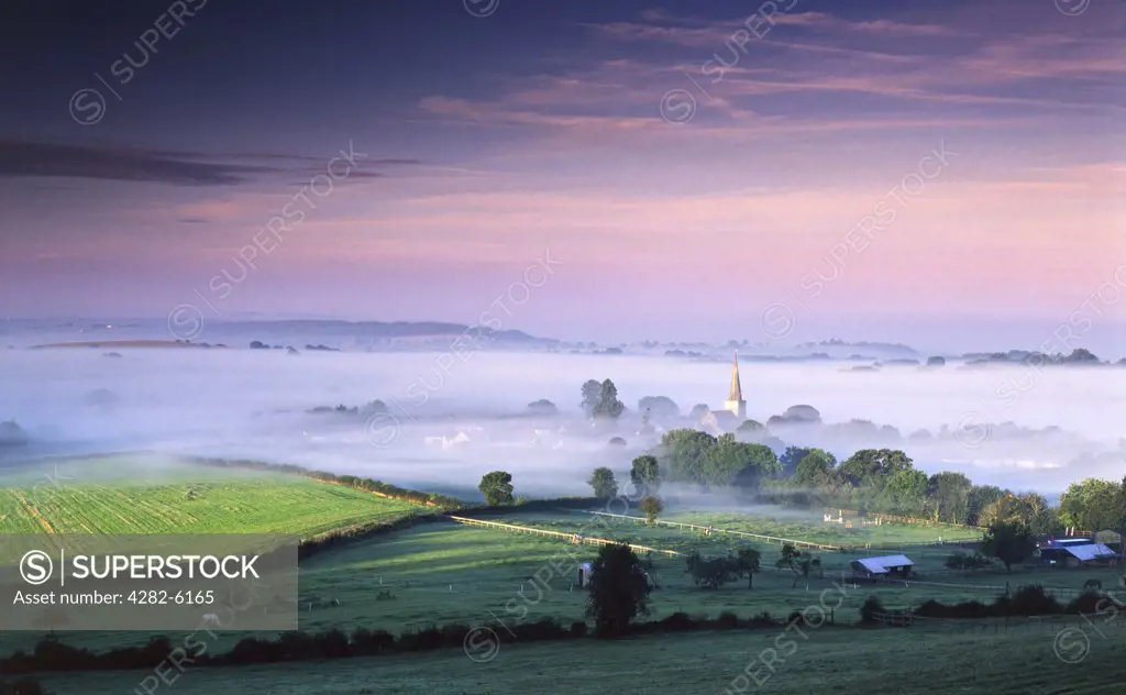 Wales, Monmouthshire, Trellech. The first rays of late summer sun strike the mist covered village of Trellech.