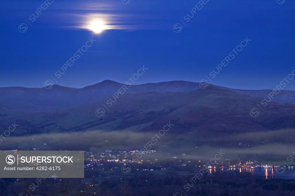 England, Cumbria, Ambleside. Moonrise over misty Ambleside.