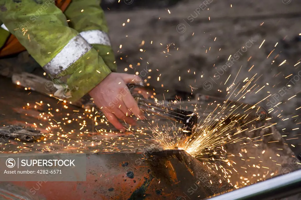 Engalnd, Wiltshire, near Avebury. A man welding during Silbury Hill renovation project.
