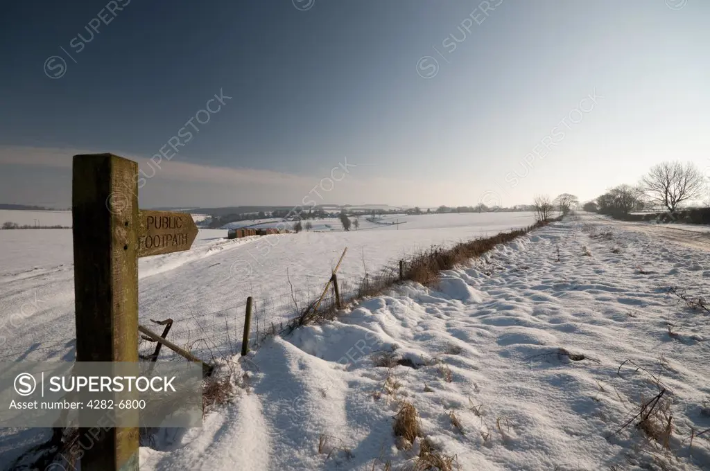 England, East Riding of Yorkshire, Huggate. A Public Footpath signpost on the snow covered Wolds Way.
