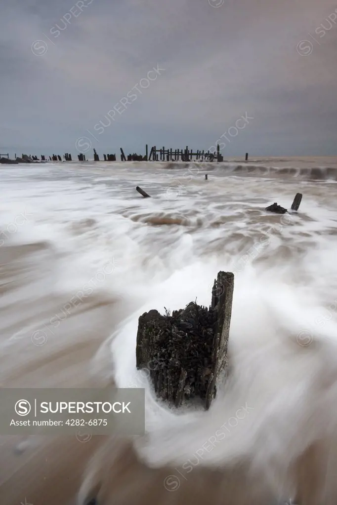 England, Norfolk, Happisburgh. Waves rolling onto the beach at Happisburgh on the Norfolk coast.
