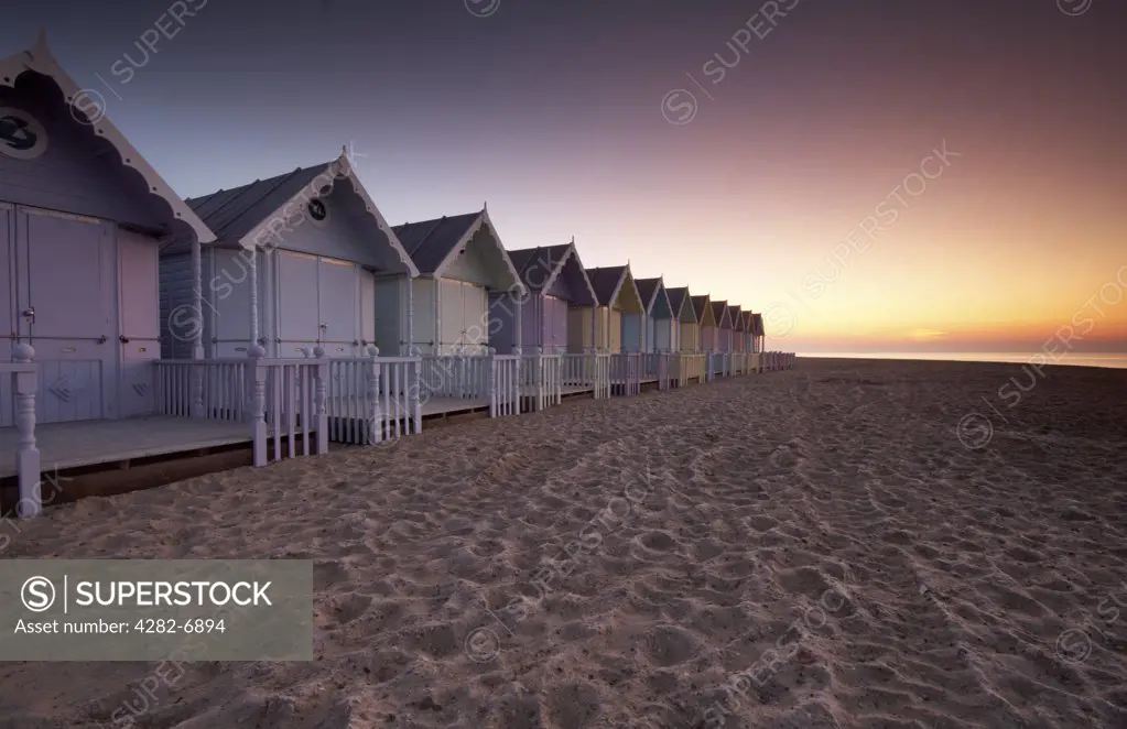 England, Essex, Mersea Island. Early dawn over new beach huts on Mersea Island.