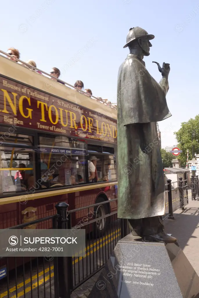 England, London, Baker Street. A sightseeing tour bus driving past the statue of Sherlock Holmes outside Baker Street tube station.