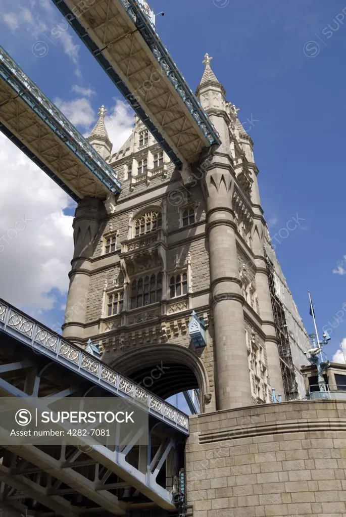 England, London, Tower Bridge. Looking up at one of the towers of Tower Bridge from a boat passing beneath on the river Thames.