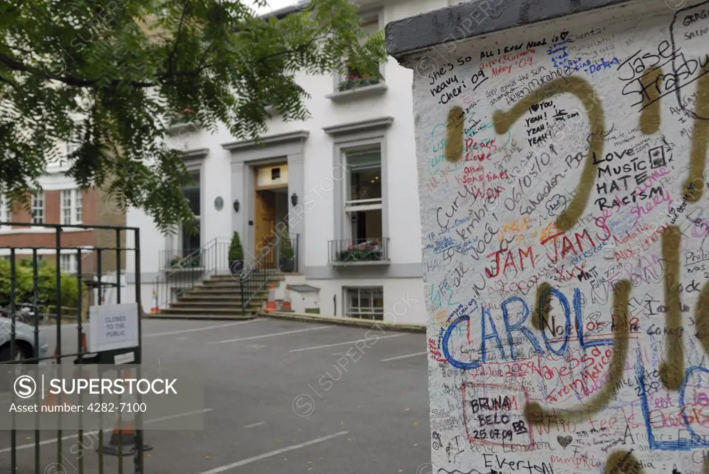 England, London, St John's Wood. Graffiti on the wall outside Abbey Road studios with the studios in the background.