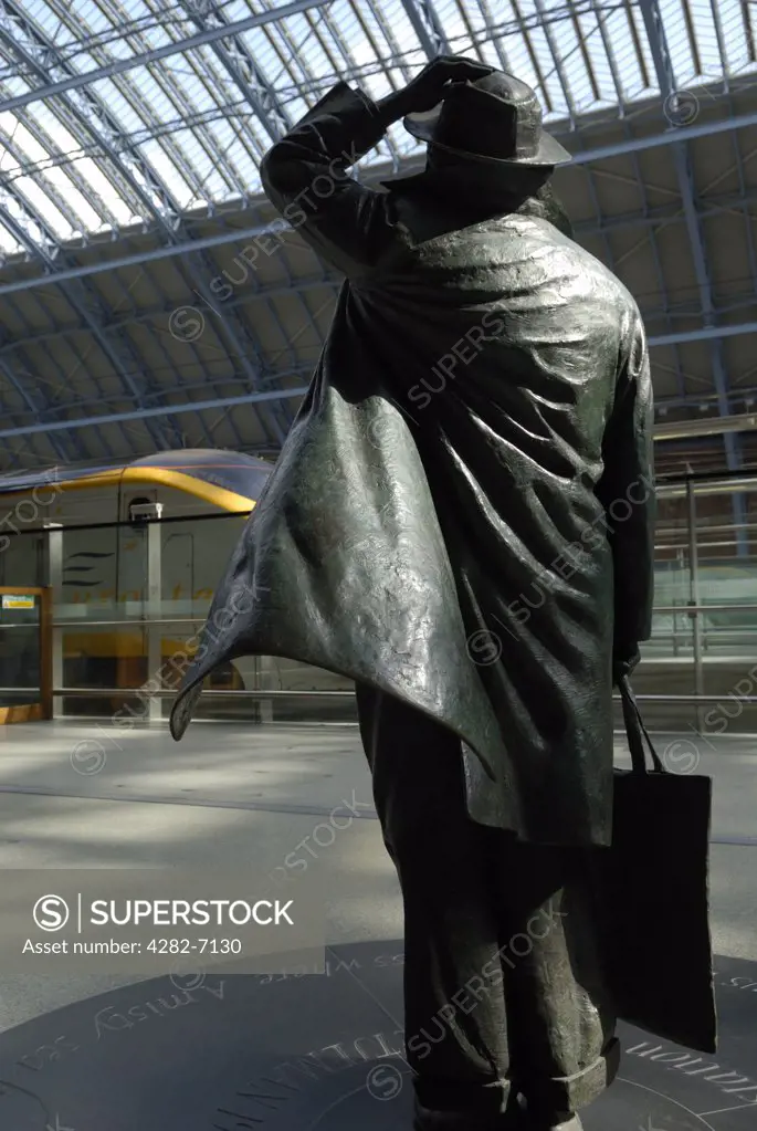 England, London, St Pancras Station. A statue of poet John Betjeman by Martin Jennings at St. Pancras International station, with a Eurostar train in the background.