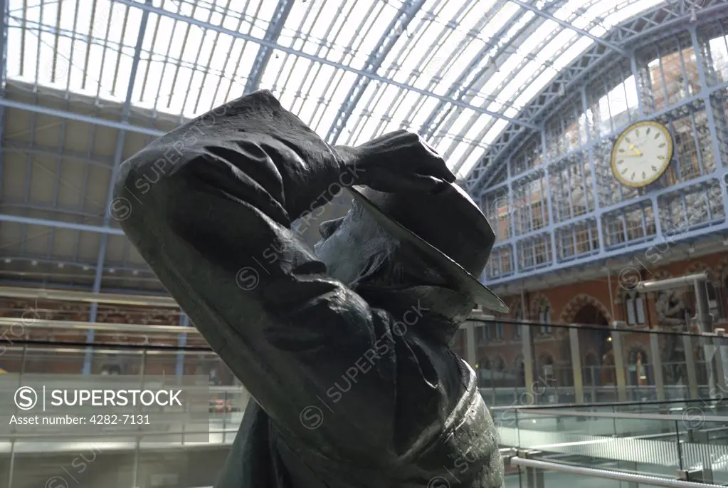 England, London, St Pancras Station. A statue of poet John Betjeman by Martin Jennings at St. Pancras International station, with the famous clock in the background.