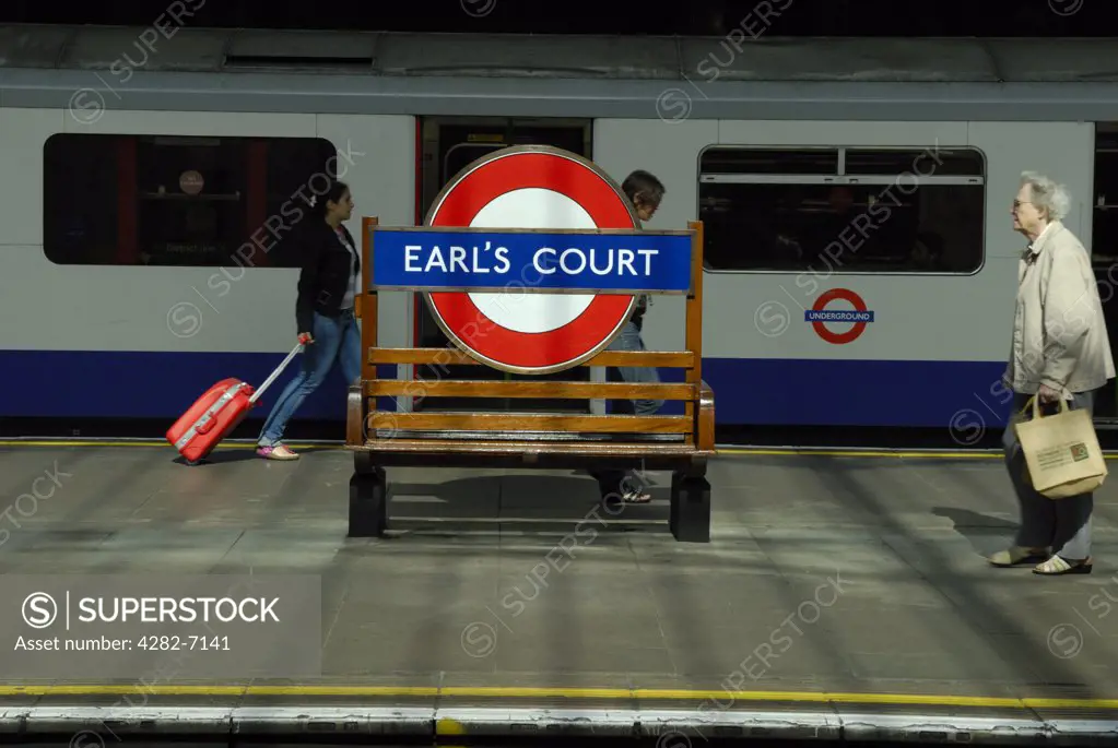 England, London, Earl's Court. Passengers walking along a platform at Earl's Court underground station.