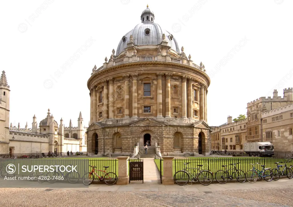 England, Oxfordshire, Oxford. Bicycles chained to the fence encircling the Radcliffe Camera building. Originally a science library, it has become a reading room of the Bodleian Library.