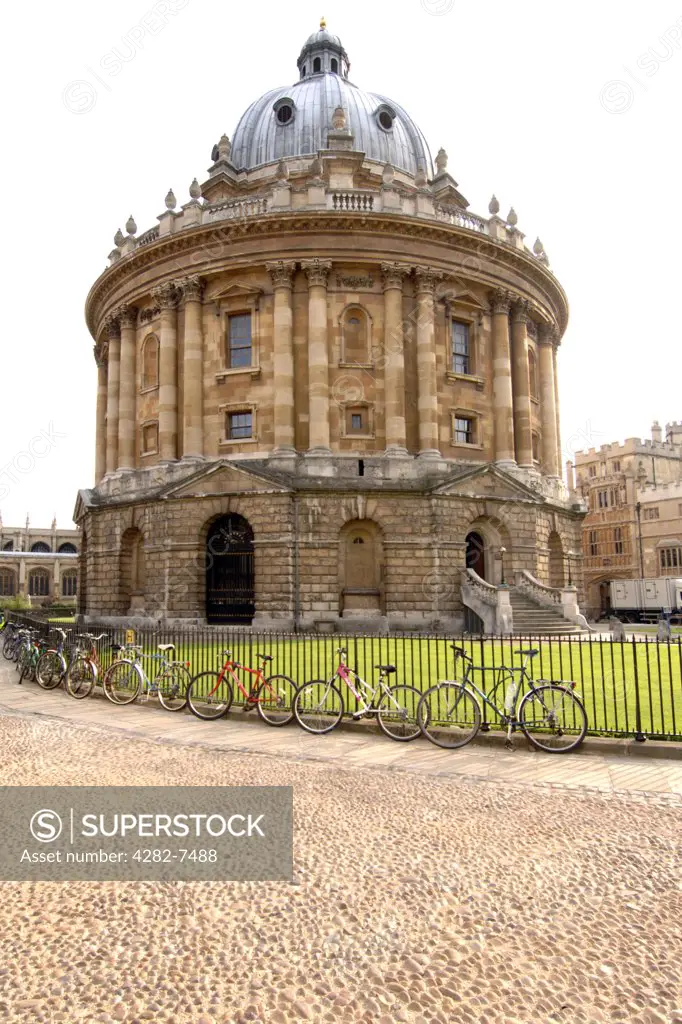 England, Oxfordshire, Oxford. Bicycles chained to the fence encircling the Radcliffe Camera building. Originally a science library, it has become a reading room of the Bodleian Library.