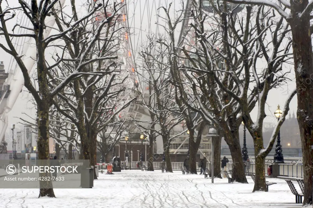 England, London, South Bank. The Thames river embankment and London Eye in view after a snowfall.