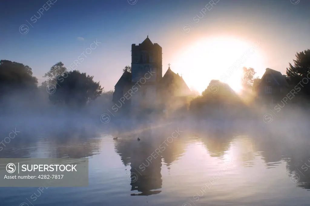 England, Buckinghamshire, Bisham. Bisham Church in the early morning mist with ducks. Bisham is home to one of the Sport England's National Sports Centres, centred on Bisham Abbey.
