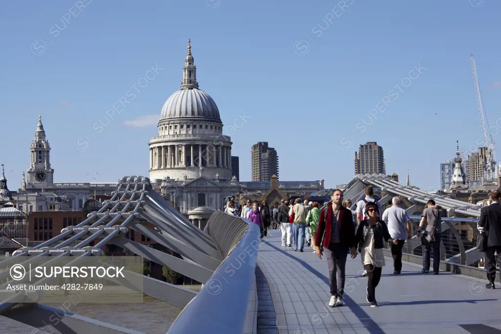 England, London, Millennium Bridge. People crossing the Millennium Bridge over the River Thames connecting St Pauls Cathedral on the north bank to Bankside on the south bank.