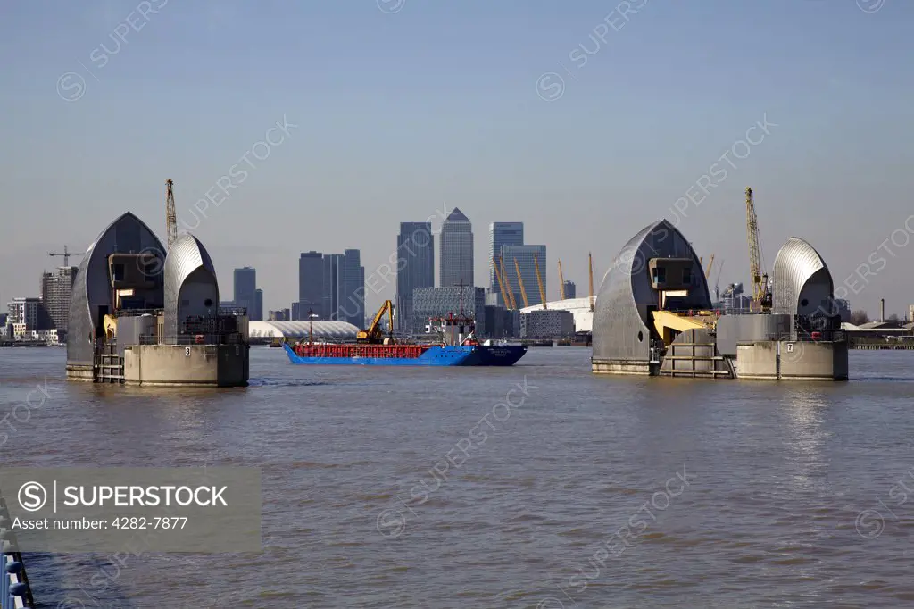 England, London, Woolwich. View over the River Thames of the Thames Barrier, O2 and skyscrapers in Canary Wharf.