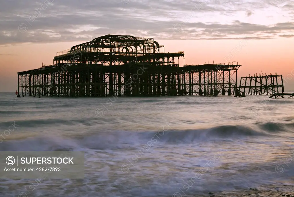 England, City of Brighton and Hove, Brighton. Sunset over Brightons decaying West Pier.
