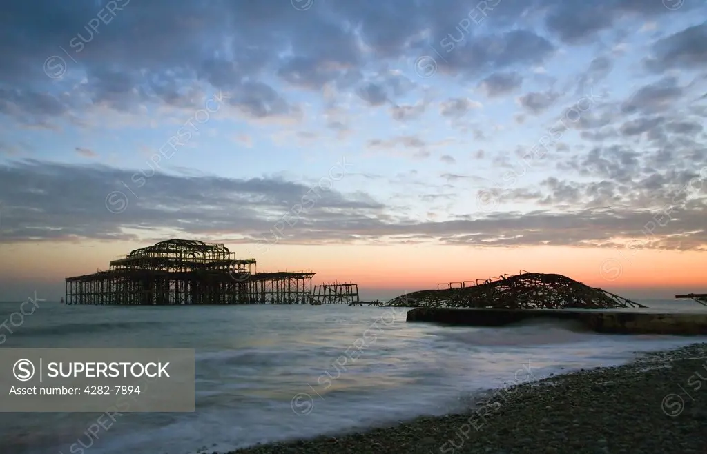 England, City of Brighton and Hove, Brighton. A dramatic winter sunset over the remains of Brightons West Pier.