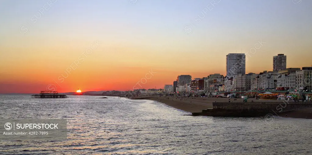 England, City of Brighton and Hove, Brighton. A view from the pier to sunset over Brighton seafront.