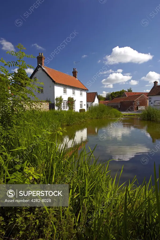 England, East Riding of Yorkshire, Bishop Burton. Cottages reflected in the village pond at Bishop Burton.