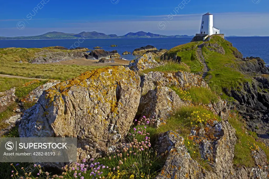Wales, Anglesey, Llanddwyn Island. Twr Mawr Light at the southern entrance to the Menai Strait within the Llanddwyn Island National Nature Reserve with Llyn peninsula in distance.