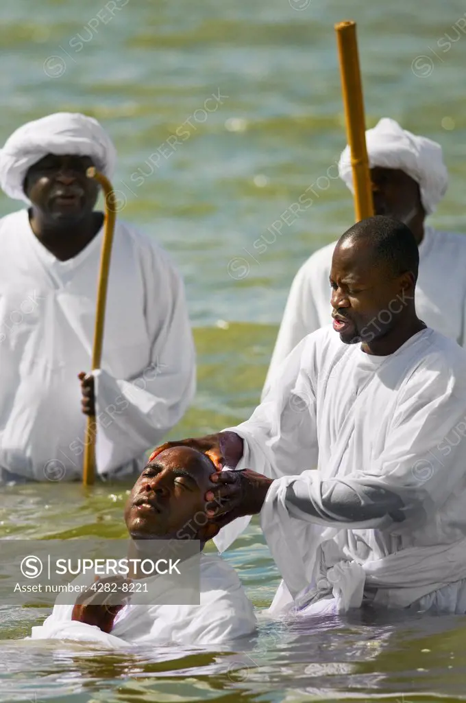 England, Essex, Southend-on-Sea. A member of an apostolic church being baptised in the sea at Southend-on-Sea.