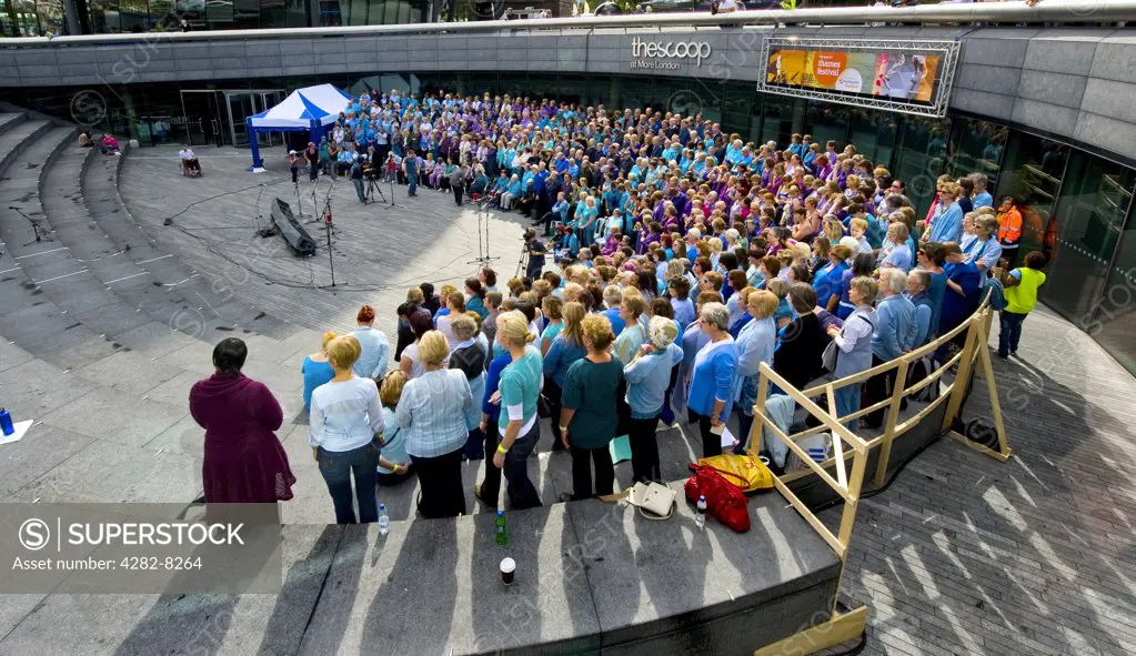 England, London, More London Riverside. A massed choir singing in support of Water Aid in The Scoop at the Thames Festival.