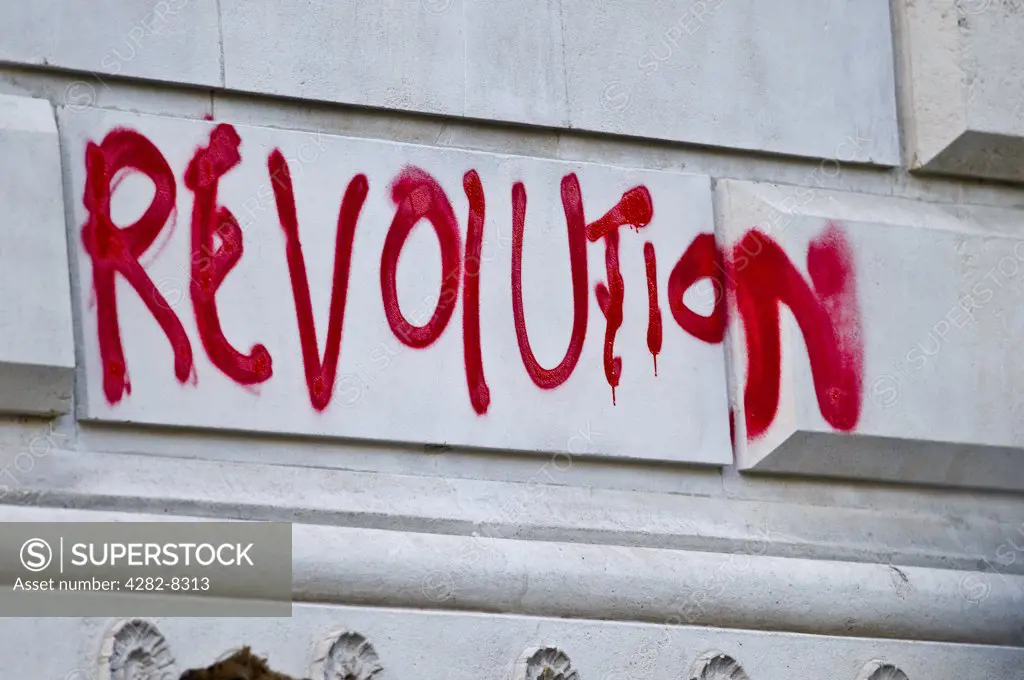 England, London. 'Revolution' written in red spray paint on a wall.