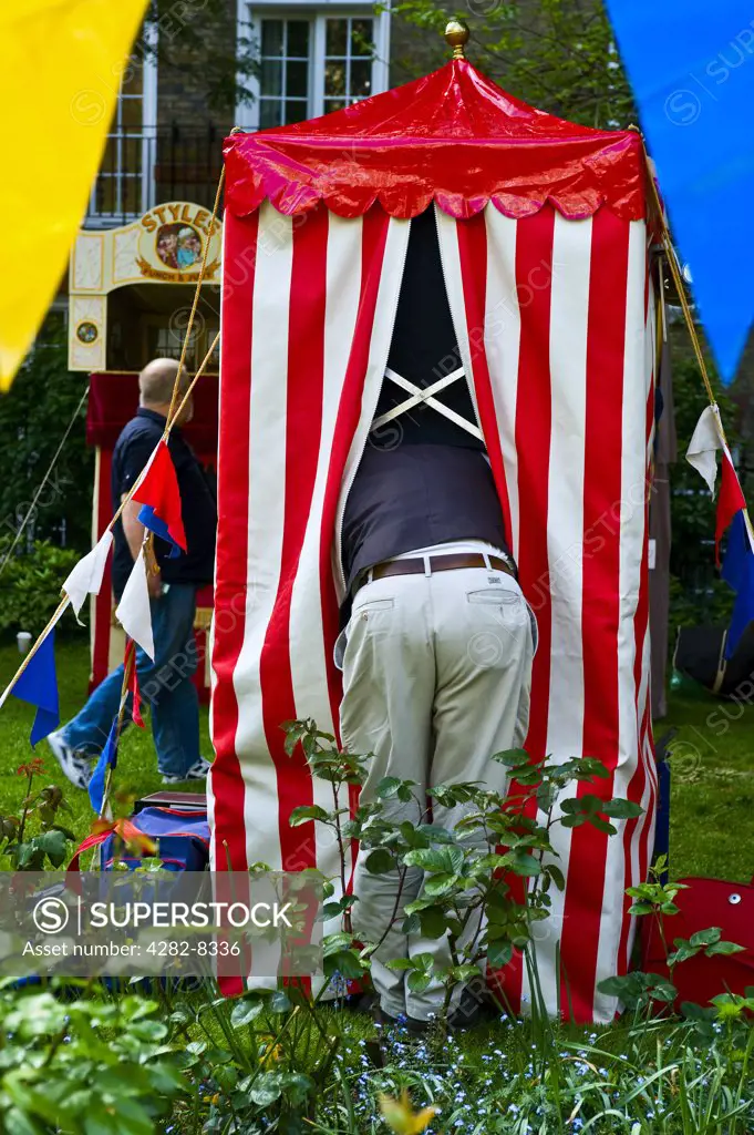 England, London, Covent Garden. A puppeteer preparing his booth for a Punch and Judy performance at the annual Punch and Judy festival in Covent Garden.