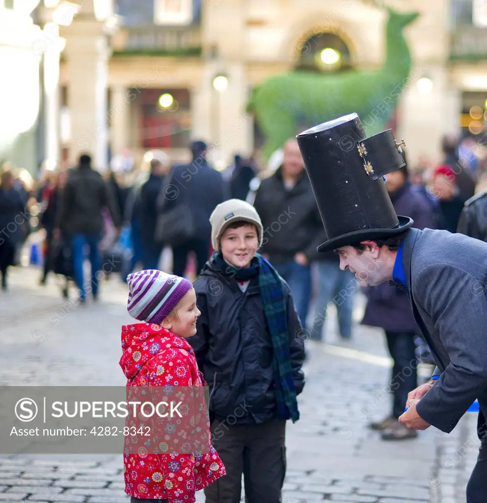 England, London, Covent Garden. A street performer entertaining children in Covent Garden.