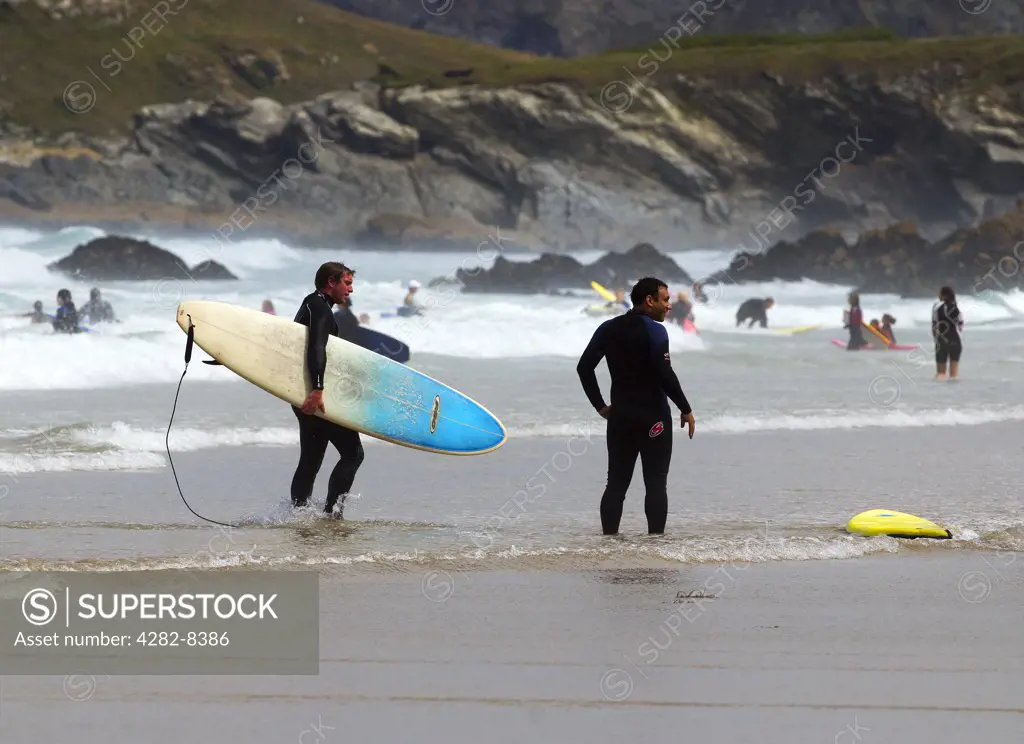 England, Cornwall, Newquay. Surfers in the sea off the coast of Newquay.