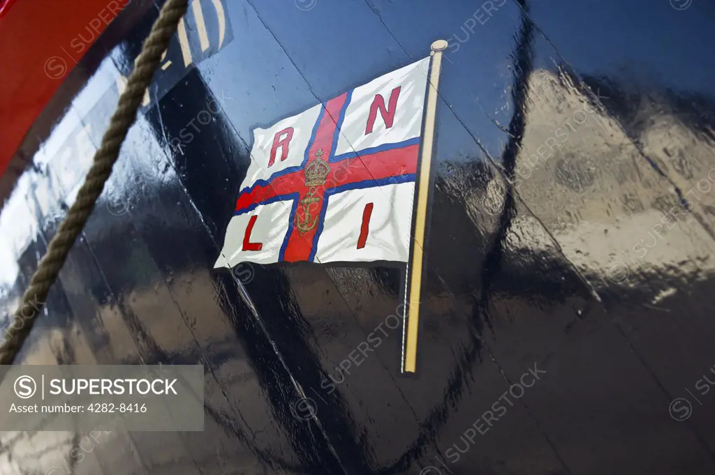 England, Kent, Chatham. The RNLI flag painted on the hull of a lifeboat at the Historic Dockyard Chatham.