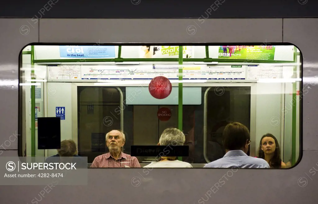 England, London, London. View through a window of passengers sitting inside a carriage of a London Underground train.