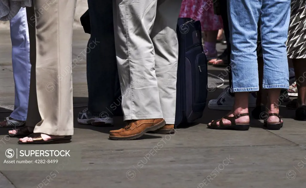 England, London. People standing in a queue.