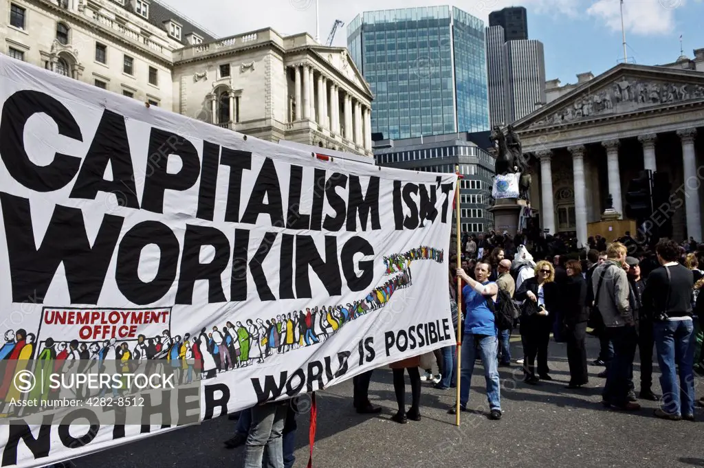 England, London, City of London. Protestors holding a large banner stating 'Capitalism Isn't Working' at the G20 demonstration in the City of London.