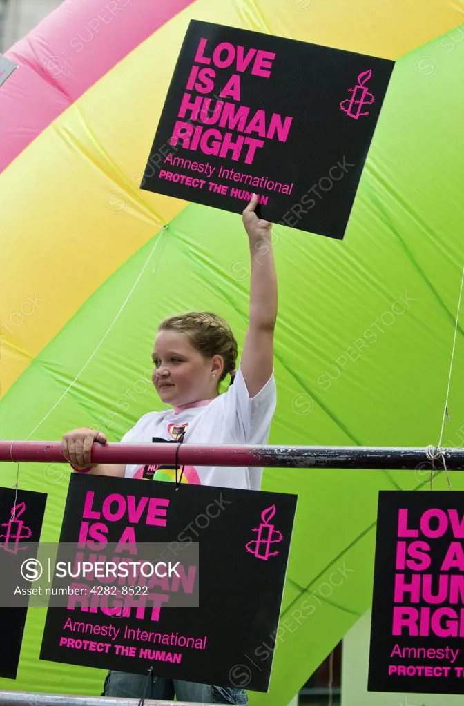 England, London. A young girl holding an Amnesty International placard stating 'Love is a Human Right' at the Pride London parade.
