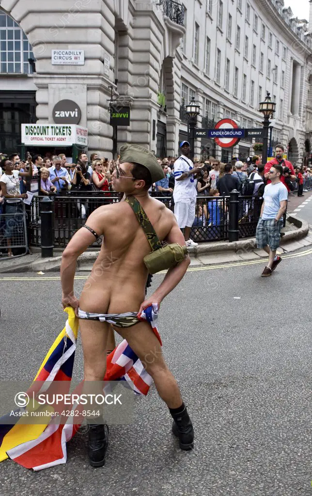 England, London, Piccadilly Circus. A participant in the Pride London Parade exposing his buttocks.