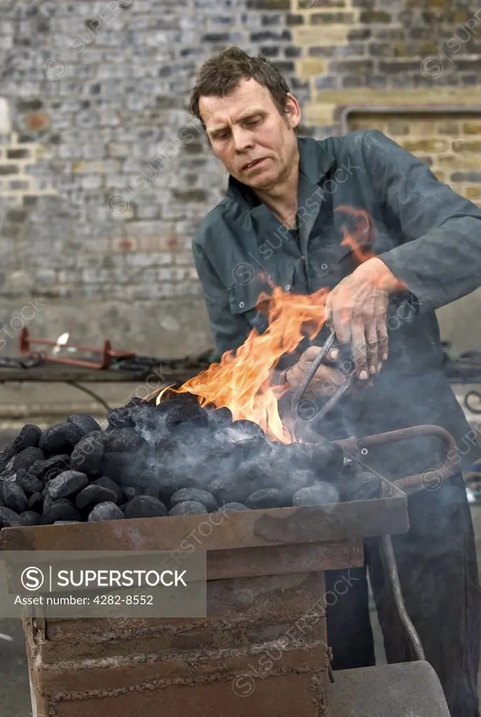 England, Kent, Chatham. A mobile blacksmith heating metal in an open furnace.