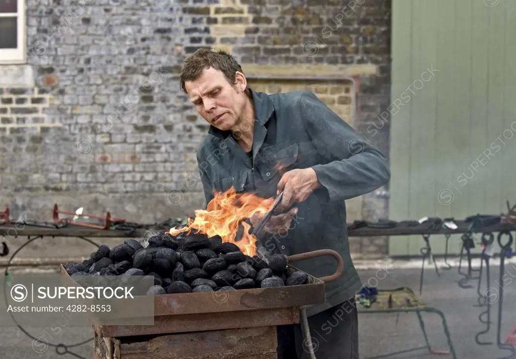 England, Kent, Chatham. A mobile blacksmith heating metal in an open furnace.
