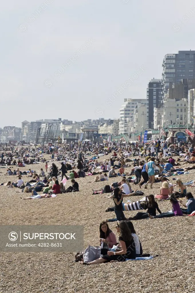 England, City of Brighton and Hove, Brighton. People relaxing on the pebble beach at Brighton.