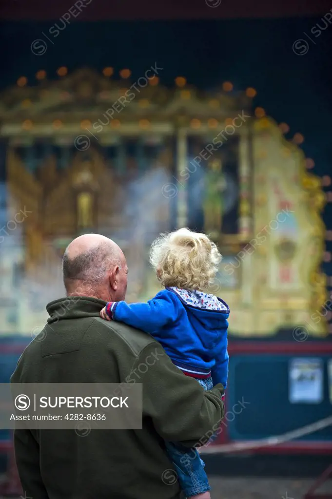 England, Essex, Audley End. A grandfather and his grandson looking at a steam organ at the Audley End Steam Gala 2011.