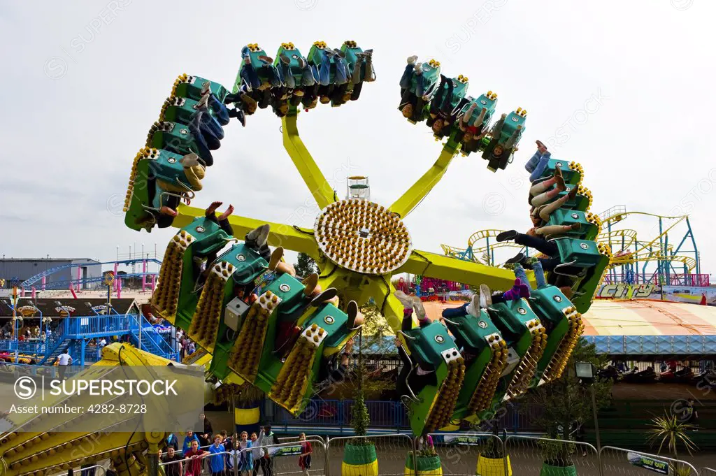 England, Essex, Southend-on-Sea. Dragon's Claw, a ride that spins people upside down at Adventure Island in Southend-on-Sea.