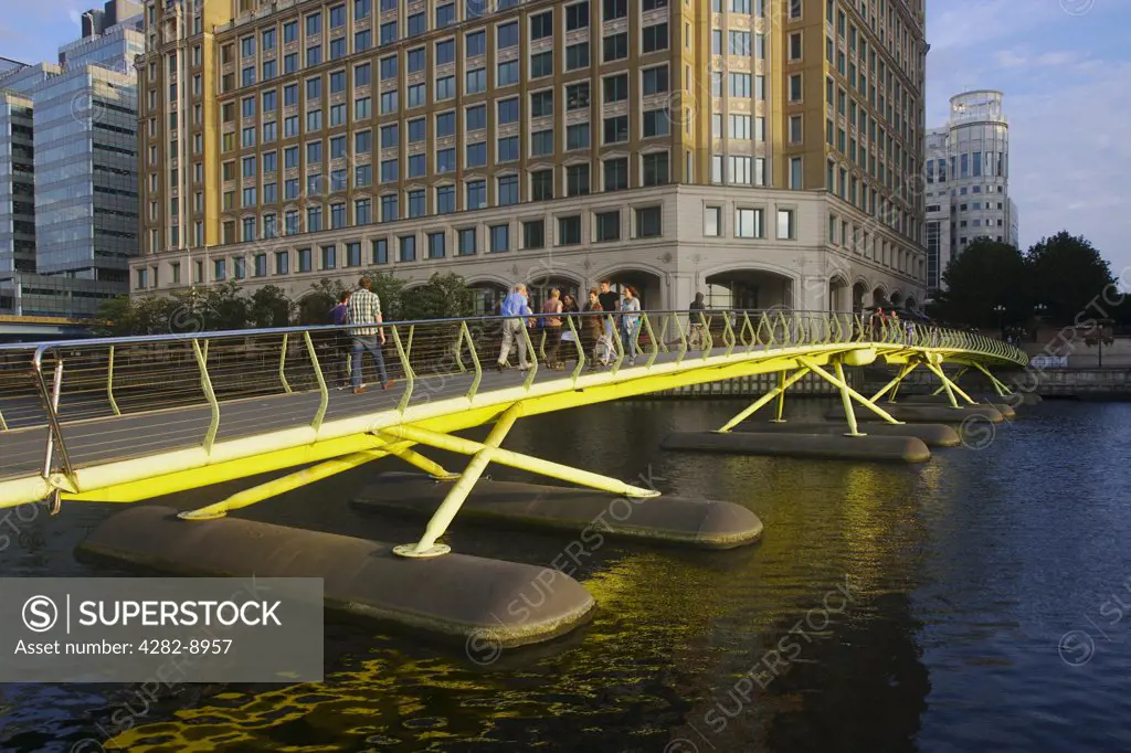 England, London, West India Quay. People crossing a footbridge at West India Quay on the Isle of Dogs in Docklands.