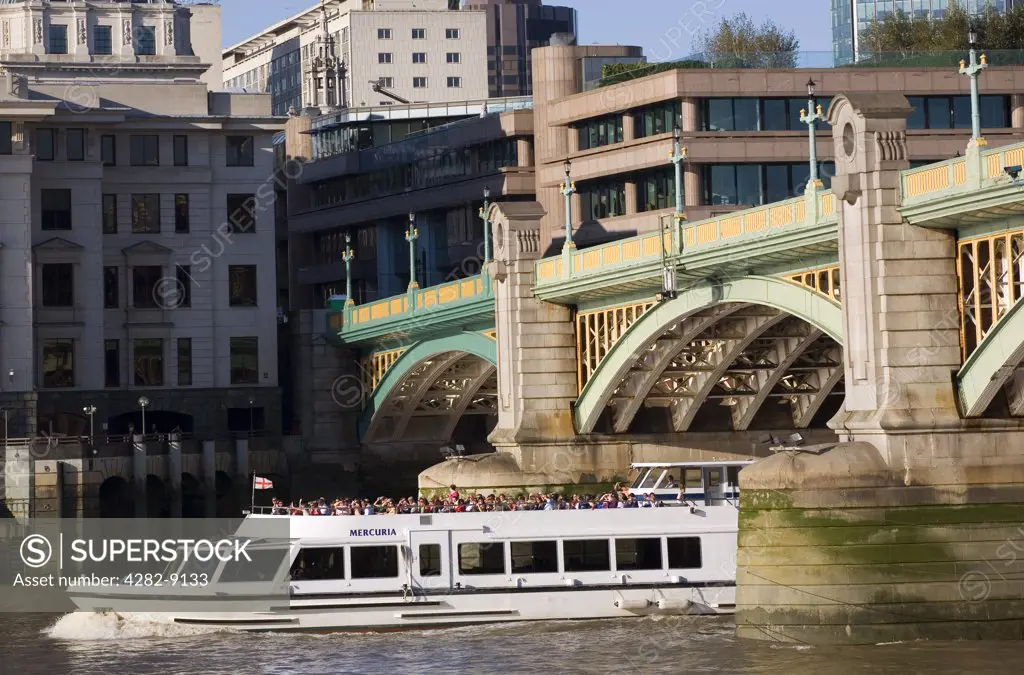 England, London, Southwark Bridge. A sightseeing boat passing under Southwark Bridge on the River Thames.