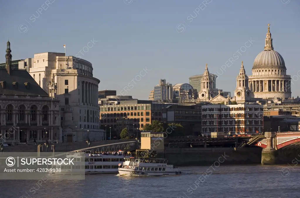 England, London, Blackfriars Bridge. Boats travelling along the River Thames with Blackfriars road bridge and St. Paul's Cathedral in the background.